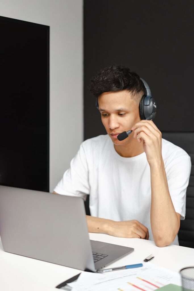 Home Support agent wearing headset working on a laptop in modern office setting.
